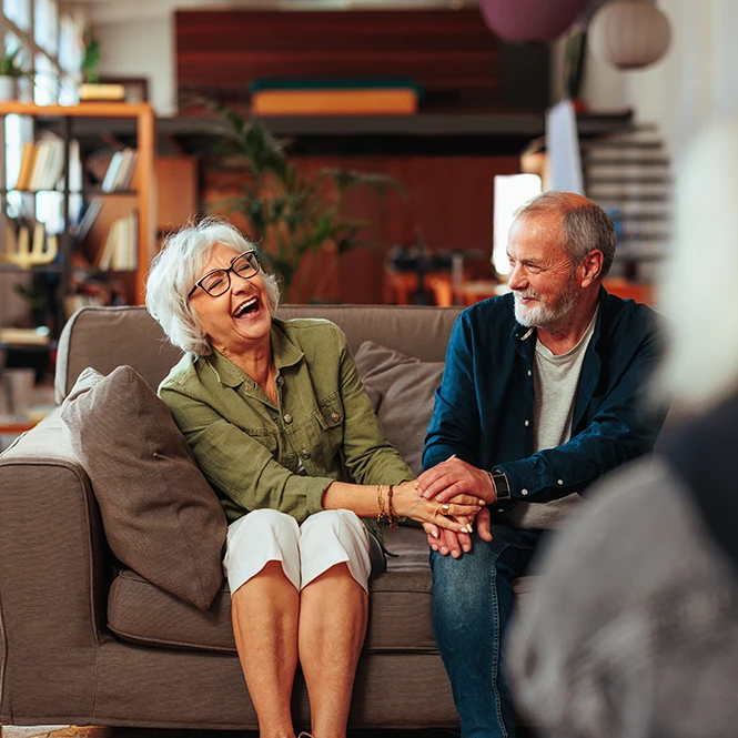 happy senior couple in therapy laughing and holding hands